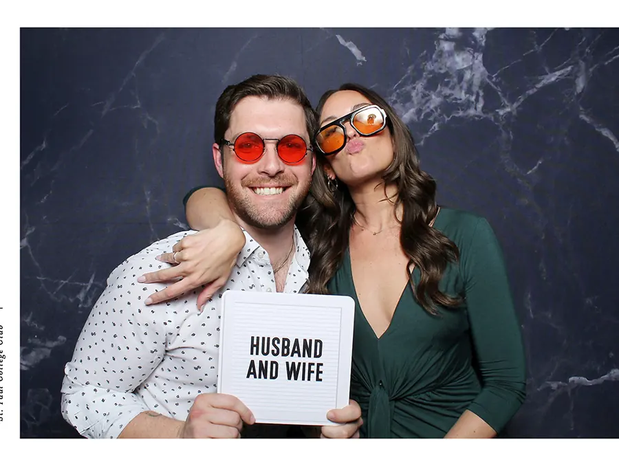 Couple holding a husband and wife sign at a photo booth