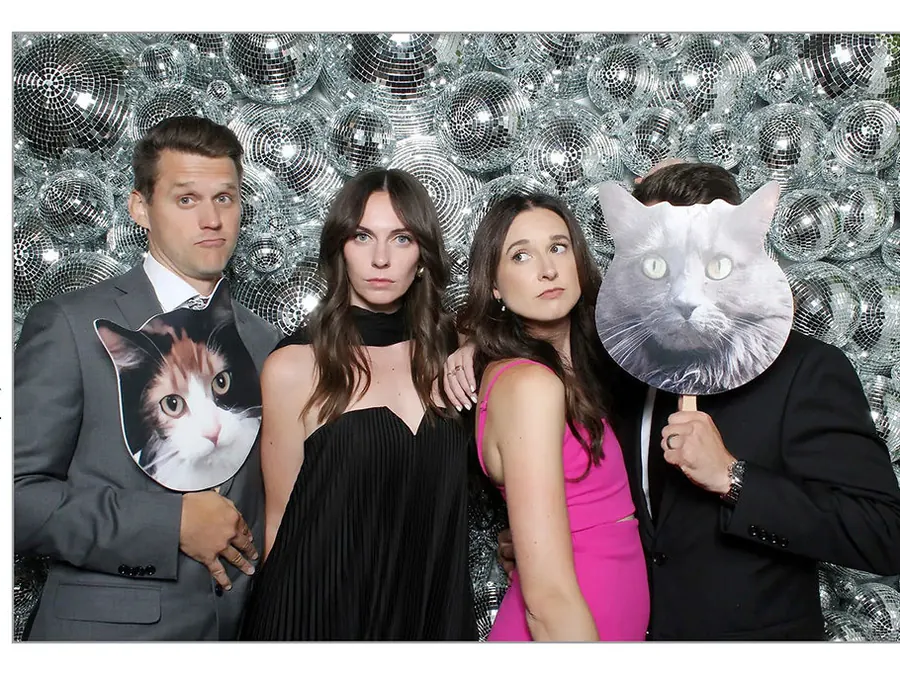 Wedding guests with giant cat face props at an open air photo booth